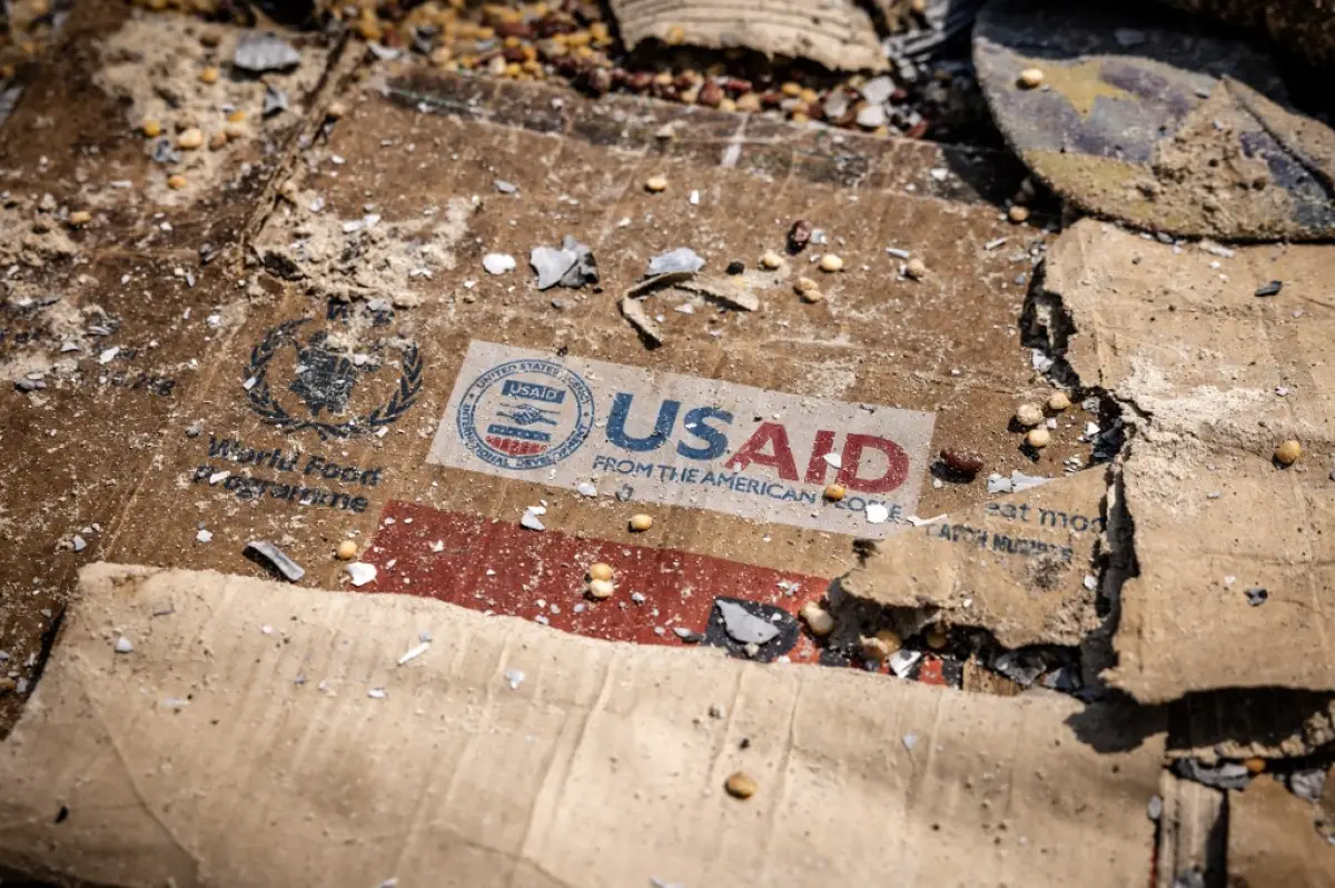 Un logotipo de USAID es visible en una caja en medio de los restos dispersos de cajas y materiales dejados por los saqueadores después de un vandalismo y saqueo generalizados después de los enfrentamientos en el almacén del Programa Mundial de Alimentos (PMA) en Bukavu el 21 de febrero de 2025.