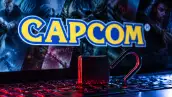 Logotipo de Capcom sobre un fondo de videojuegos con tonos azules y rojos. En primer plano, un candado abierto sobre un teclado de computadora representa una vulnerabilidad de seguridad informática.