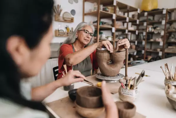 Senior woman making a craft product on a ceramics workshop