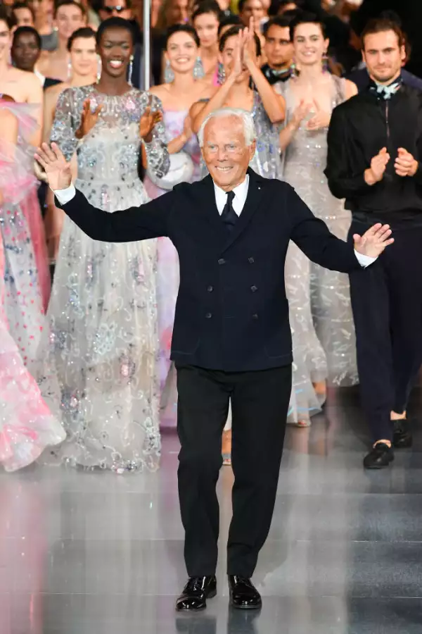 Foto de Giorgio Armani, vestido con traje y corbata negros, camina por una pasarela en Dubai en octubre de 2021.