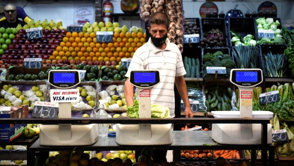 (Hombre recorre los pasillos de una verdulería)