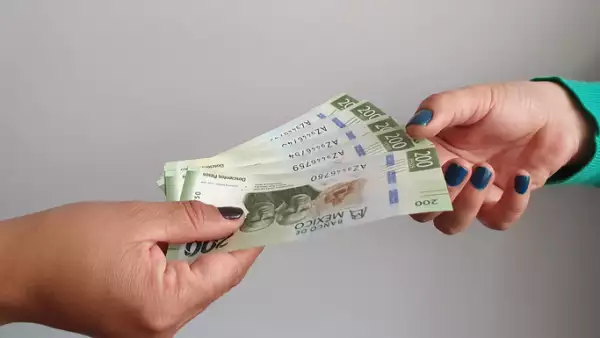women hands paying and receiving mexican money