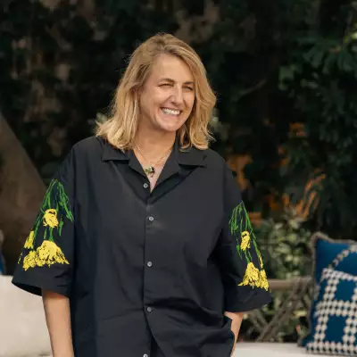 Foto de la arquitecta Patricia Urquiola con camisa over sized negra con mangas de flores amarillas.