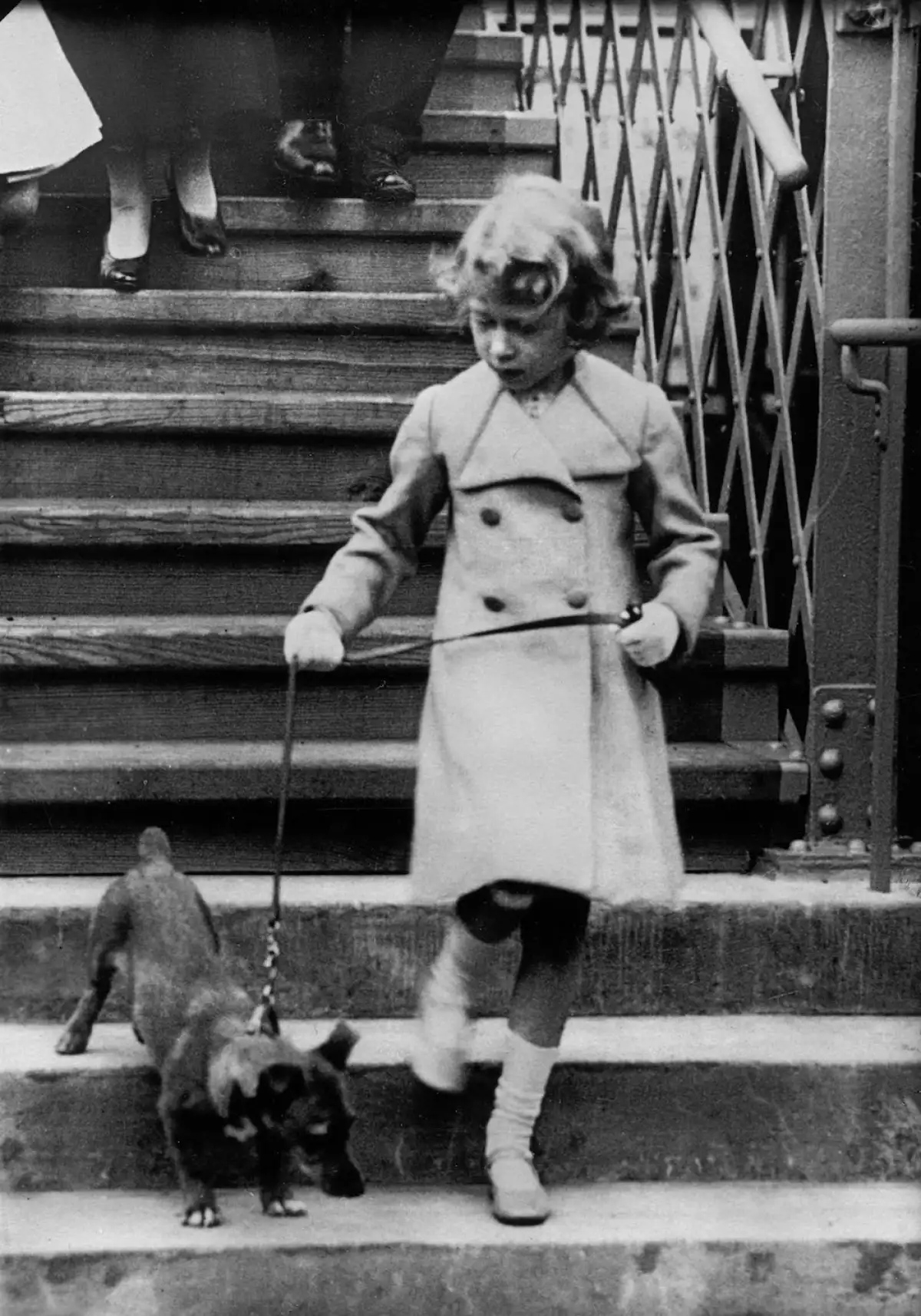 Princess Elizabeth of England takes her dog for a walk. Photograph. Around 1931.