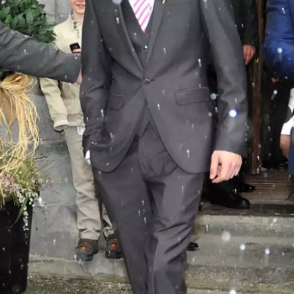 Llevó un traje gris de tres piezas combinado con una corbata a rayas que hacía juego con la del novio.