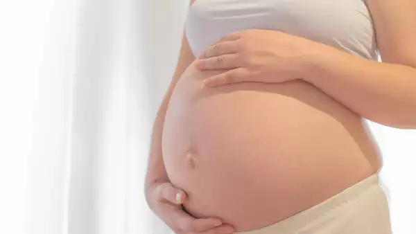 Pregnant woman with hand on belly.