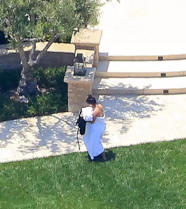 La esposa de Kanye West se cubrió con una toalla y se dirigió al interior de su casa al percatarse de que la fotografiaban.