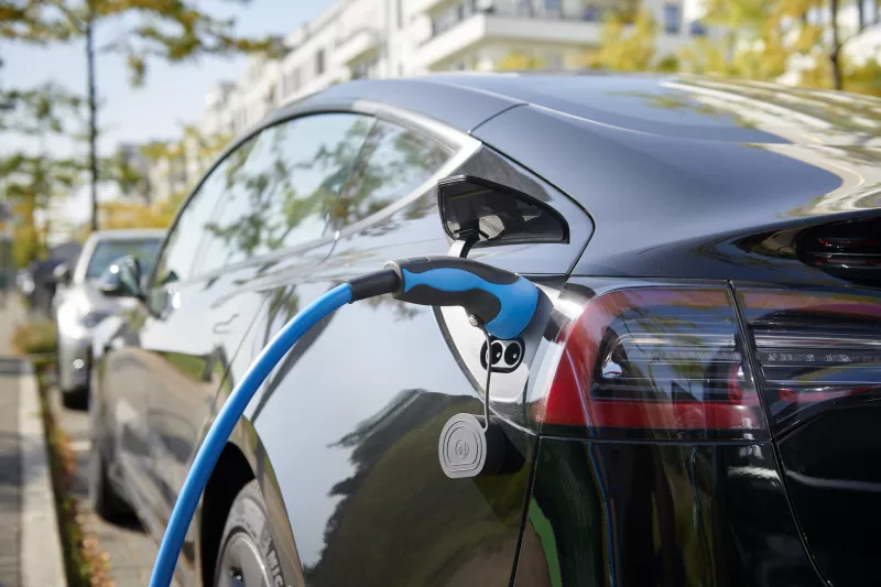 Black Tesla Model S electric car connected to a recharging station