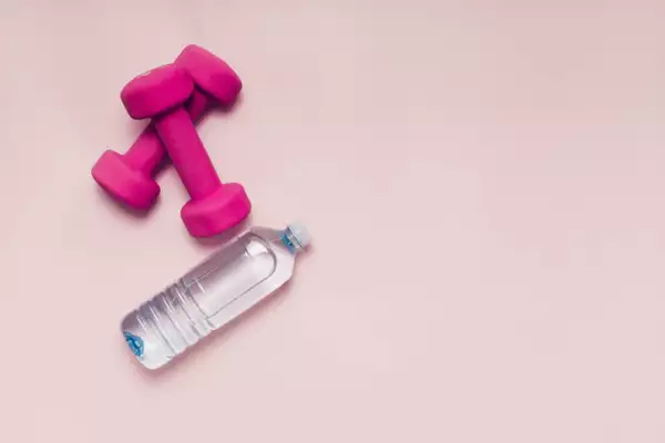 Mancuernas rosas con botella de agua