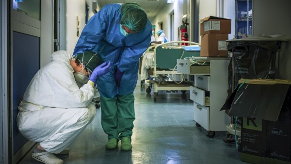 Una enfermera con máscara protectora y equipo conforta a otro mientras cambian de turno el 13 de marzo de 2020 en el hospital de Cremona, al sureste de Milán, Lombardía, durante el cierre del país destinado a detener la propagación de la pandemia del coronavirus.