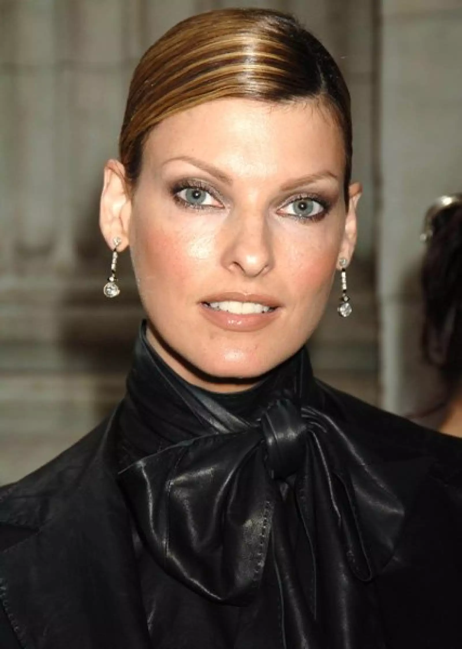 Elegante y sofisticada con el pelo recogido y raya al medio.