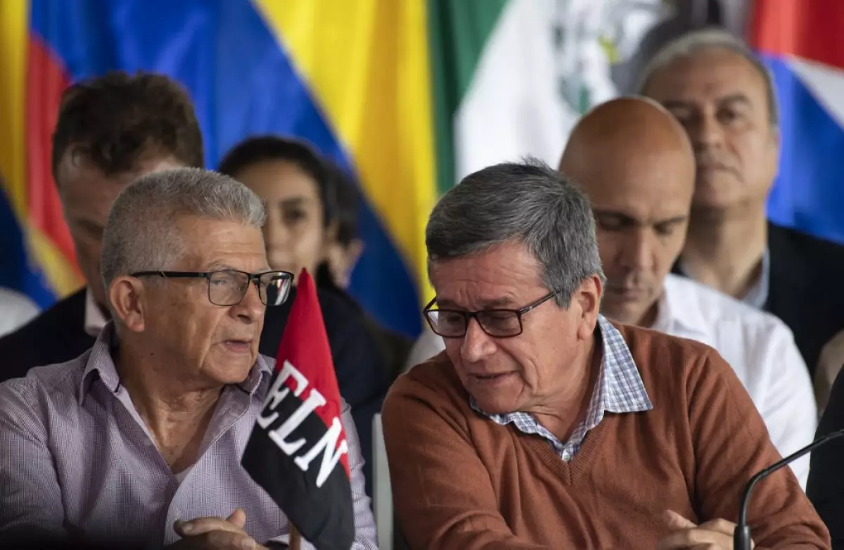En esta foto de archivo tomada el 21 de enero de 2023, los comandantes guerrilleros del Ejército de Liberación Nacional (ELN) de Colombia Pablo Beltrán (derecha) y Aureliano Carbonell (izquierda), acompañados por miembros de la delegación del gobierno colombiano (fuera de marco), hablan durante la lectura de un documento luego de una reunión en el marco de los diálogos de paz en el complejo "La Casona Cultural Aquiles Nazoa" en Caracas.