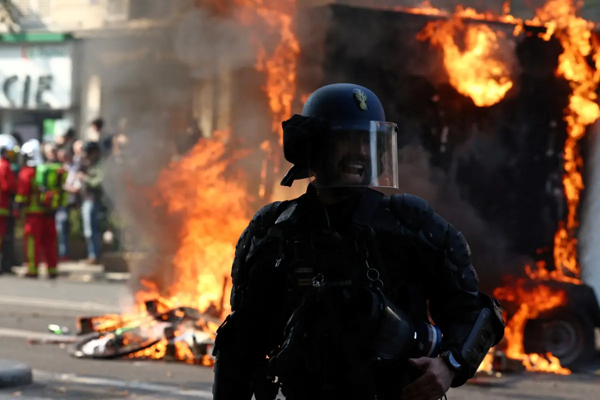 Un gendarme francés reacciona frente a un remolque de construcción en llamas durante una manifestación como parte del decimocuarto día de protestas a nivel nacional contra la ley de reforma de pensiones del gobierno francés, en París, Francia, el 6 de junio de 2023.