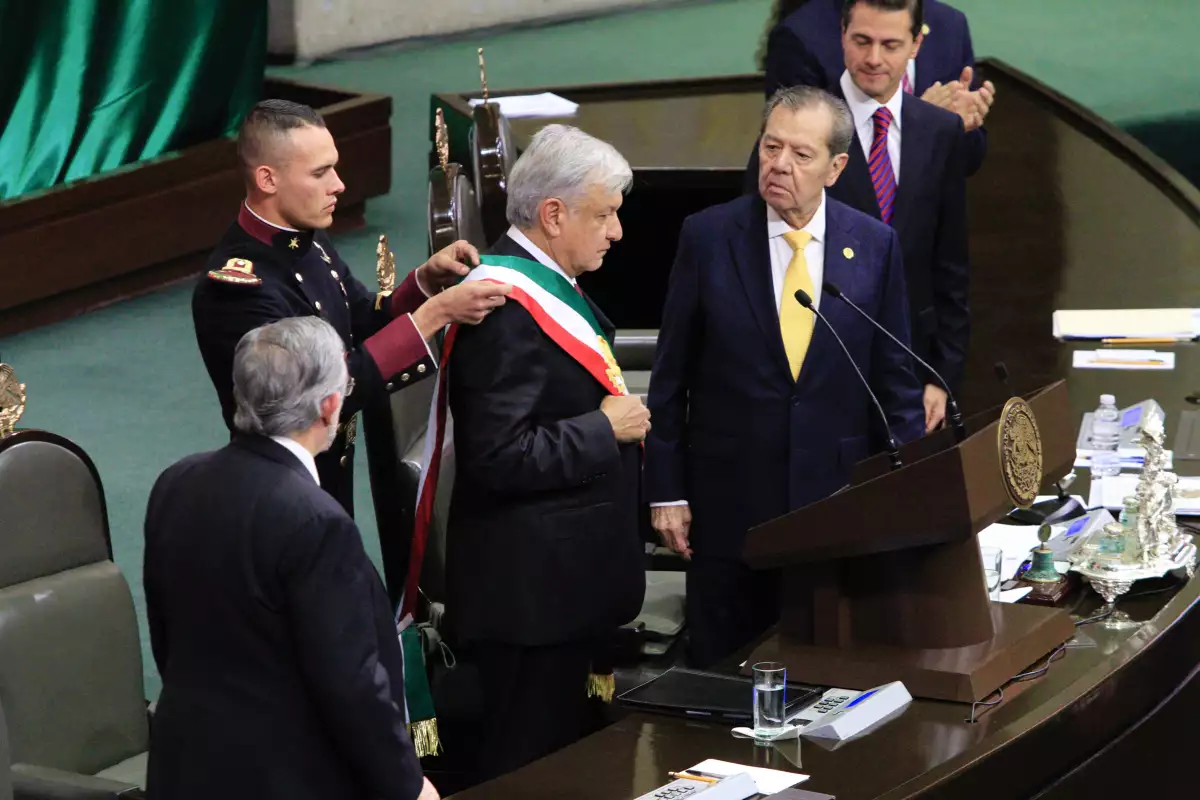Geovanni Lizarraga ayudó al ahora presidente a acomodarse la banda presidencial.