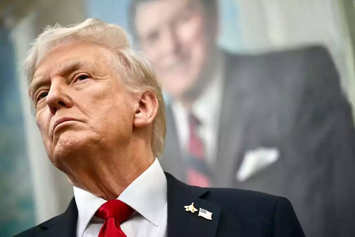 Un retrato del expresidente estadounidense Ronald Reagan cuelga detrás del presidente estadounidense Donald Trump mientras Trump hace un anuncio sobre medicamentos recetados en la Oficina Oval de la Casa Blanca en Washington, DC, el 30 de septiembre de 2025.