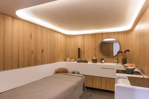 Cabina de spa con un espejo circular y paredes de mader
