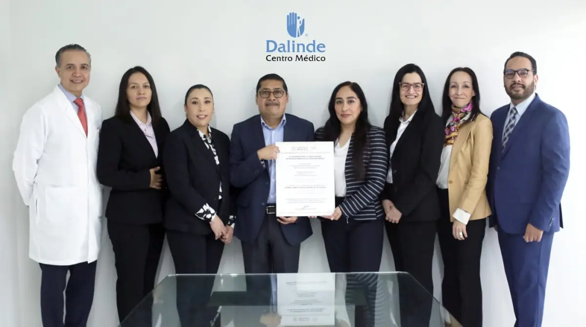 Directivos de Centro Médico Dalinde, hay ocho personas: 5 mujeres y tres hombres quienes están de pie. Un hombre y una mujer están sosteniendo un reconocimiento.