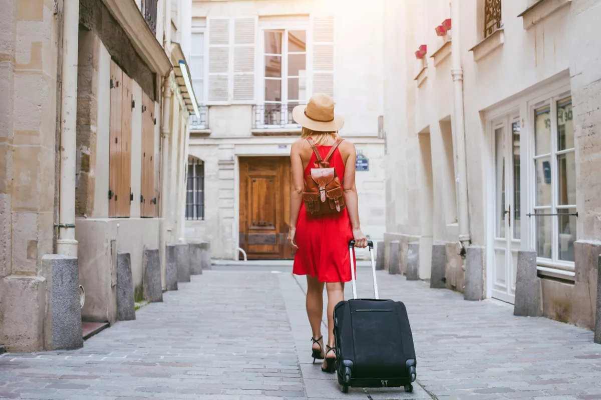 hotel, tourist walking with suitcase on the street