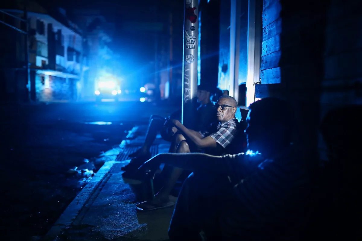  Jaime Degraff se sienta afuera, intentando refrescarse mientras la gente espera la reparación de la red eléctrica dañada tras el paso del huracán María el 23 de septiembre de 2017 en San Juan, Puerto Rico. Puerto Rico sufrió daños generalizados tras el paso del huracán María, un huracán de categoría 4.