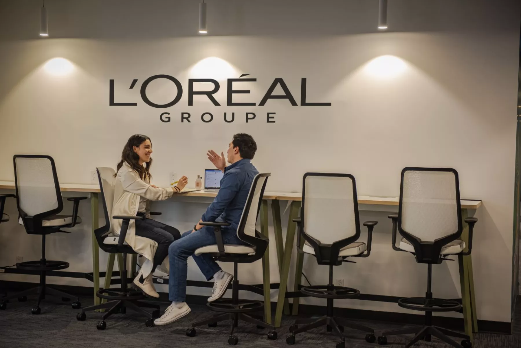Dos colaboradores de Grupo L'Oréal están conversando en las oficinas de esta Súper Empresa.