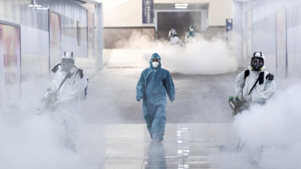 Volunteers in protective suits disinfect a railway station as the country is hit by an outbreak of the new coronavirus, in Changsha