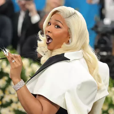 Foto de Lizzo a la llegada de la MET Gala 2025 con cabello rubio y labios pintados de negro.