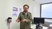 Zoé Robledo, director general del IMSS, habla frente a una cámara en un consultorio médico, con equipo de atención y una computadora al fondo.