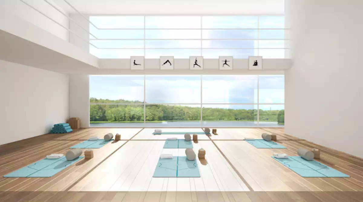 Estudio de yoga con ventana grande y tapetes azules.