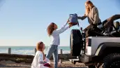 Three,Young,Adult,Girlfriends,Unloading,Backpacks,From,A,Car