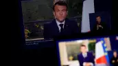 El presidente francés Emmanuel Macron aparece en una pantalla, mientras habla durante un discurso especial a la nación desde el Palacio del Elíseo, después de que promulgara la reforma de las pensiones que eleva la edad de jubilación, en París, Francia, el 17 de abril de 2023.