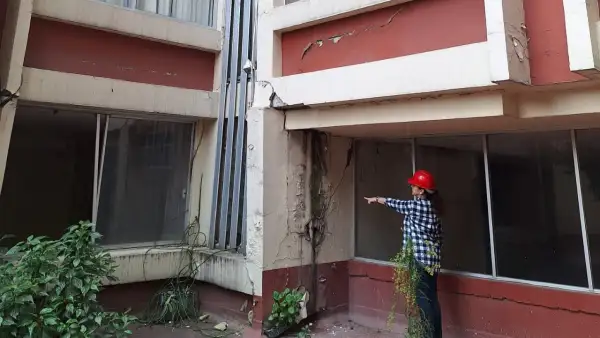 Una mujer muestra los daños en una columna de Aguascalientes 12, Roma Sur, donde 70 departamentos dañados por el sismo del 19 de septiembre de 2017 aún no son reconstruidos.