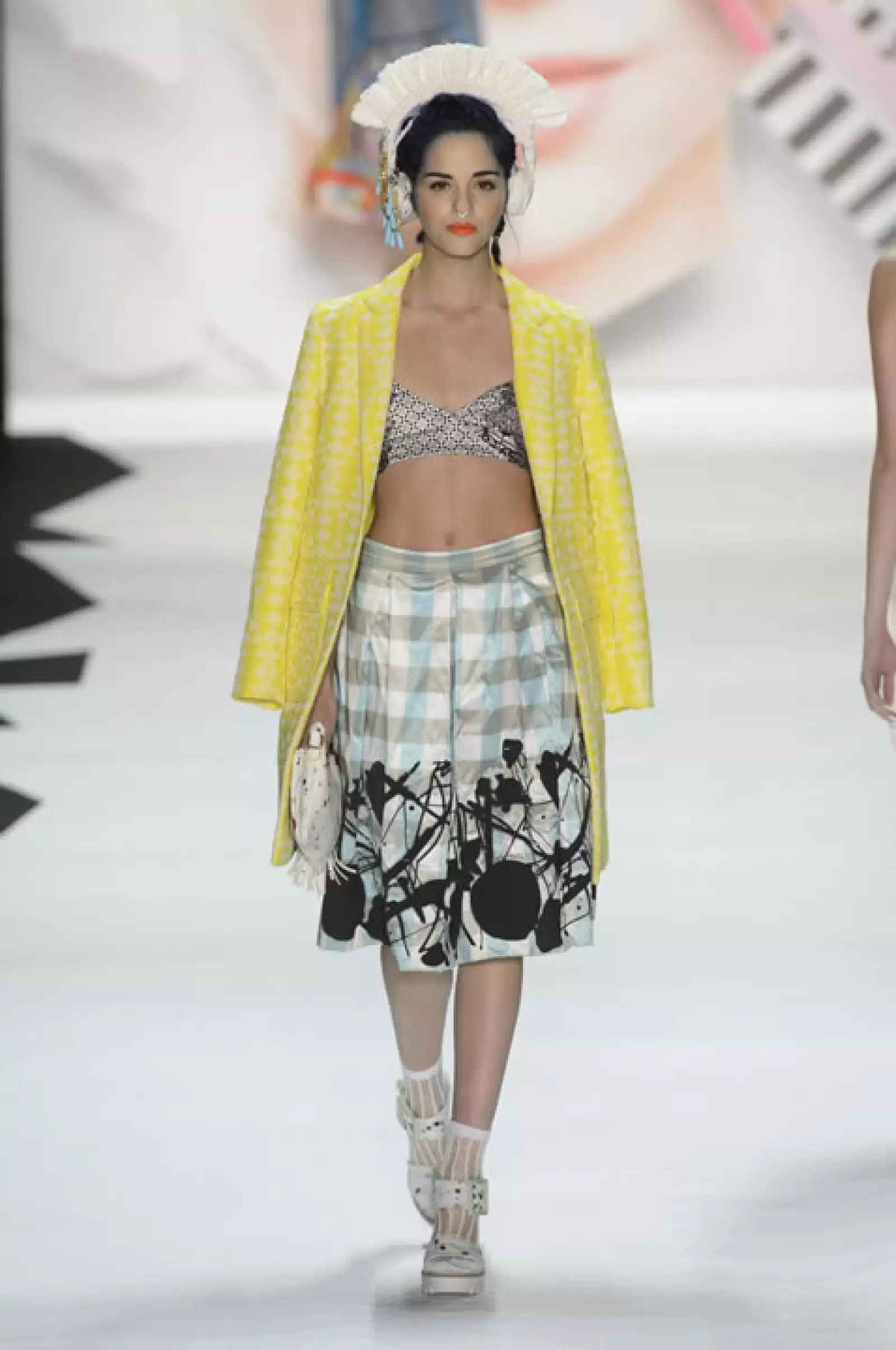 Abrigo en amarillo con estampado geométrico sobre crop top de algodón y falda en corte A. Sandalias de plataforma.
