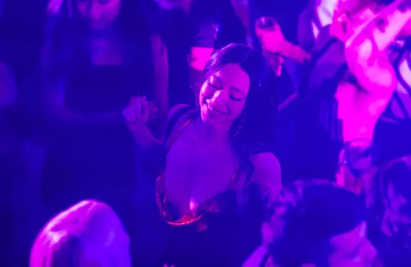 Foto de una escena de 'Anora' con Mikey Madison como Ani bailando en medio de un antro.