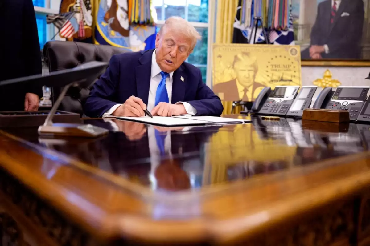 El presidente de los Estados Unidos, Donald Trump, firma una orden ejecutiva en la Oficina Oval de la Casa Blanca el 19 de septiembre de 2025 en Washington, DC. Trump firmó dos órdenes ejecutivas, estableciendo la "Trump Gold Card" e introduciendo una tarifa de 100.000 dólares para visas H-1B.