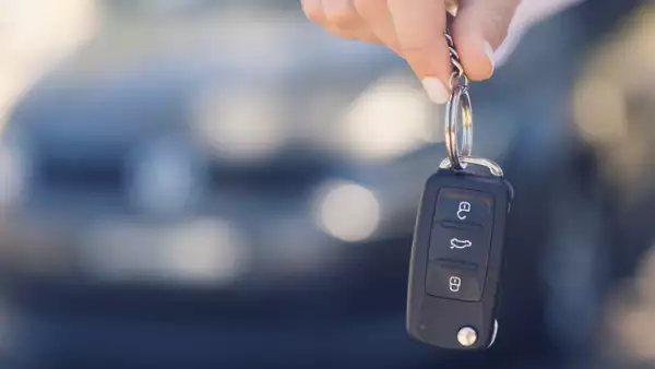 Female car salesperson handing  over the new car keys.