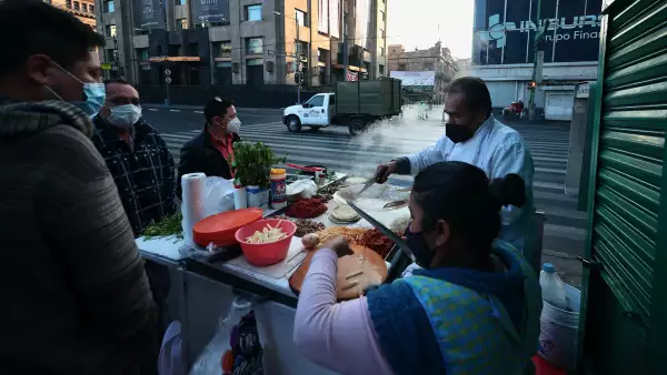 (Gente desayuna en un puesto de comida, ubicado en la calle de Eje Central. CDMX)