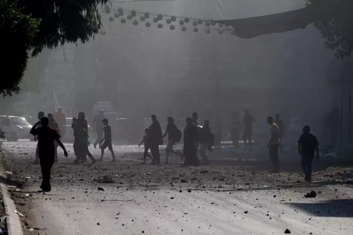 Contenido gráfico / Los palestinos evacuan un vecindario de la ciudad de Gaza durante los ataques aéreos israelíes el 11 de octubre de 2023, mientras continuaban las furiosas batallas entre Israel y el movimiento de Hamas por quinto día consecutivo
