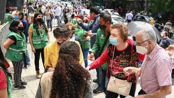 Una pareja de adultos mayores intenta entrar al centro de vacunación.