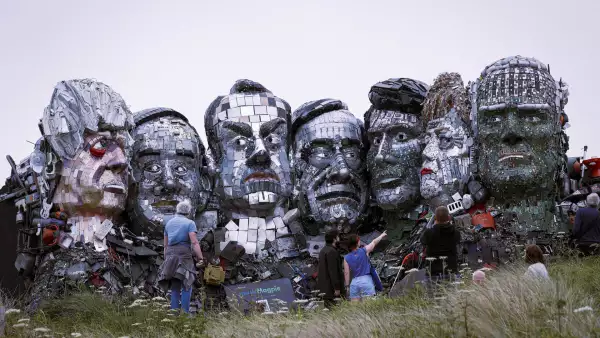 El cambio climático es también una de las prioridades del G7. La gente mira una escultura gigante al estilo del Monte Rushmore de las cabezas de los líderes del G7, hecha por los artistas Joe Rush y Alex Wreckage completamente de productos electrónicos desechados, en una playa cerca de Carbis Bay, Cornwall.