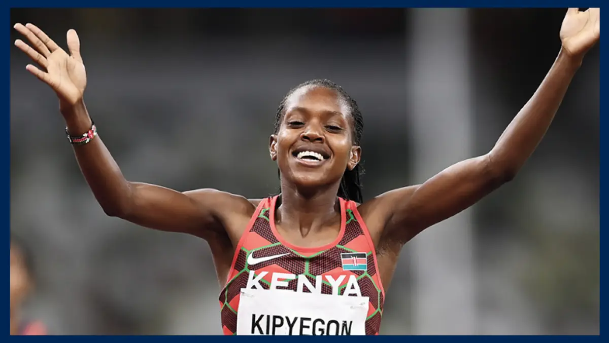 Foto de la corredora keniana Faith Kipyegon terminando una carrera con los brazos abiertos.