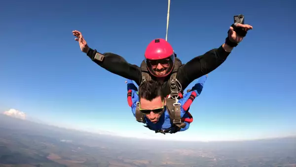 Foto de hombre en salto libre con paracaidas.
