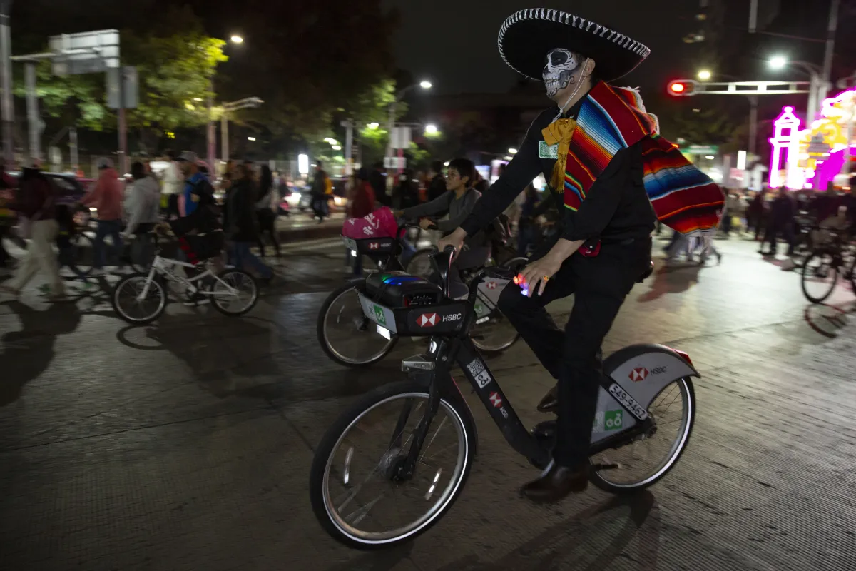 hombre vestido de charro pasea en una bici de Ecobici durante el Paseo Nocturno de Dia de Muertos 2026