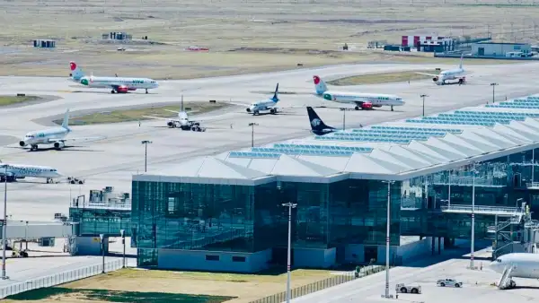 Un total de 8 aviones estacionados sobre la pista el aeropuerto del aifa. Es de día, los aviones son blancos con vivos rojosjpg