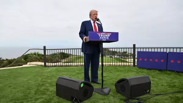 Trump, un hombre blanco de 78 años, regresa a la campaña luego de su segundo intento de asesinato. En la imagen se aprecia a Trump dentro del 'Trump National Golf Club' con un traje azul marino y corbata roja dando una conferencia de prensa.