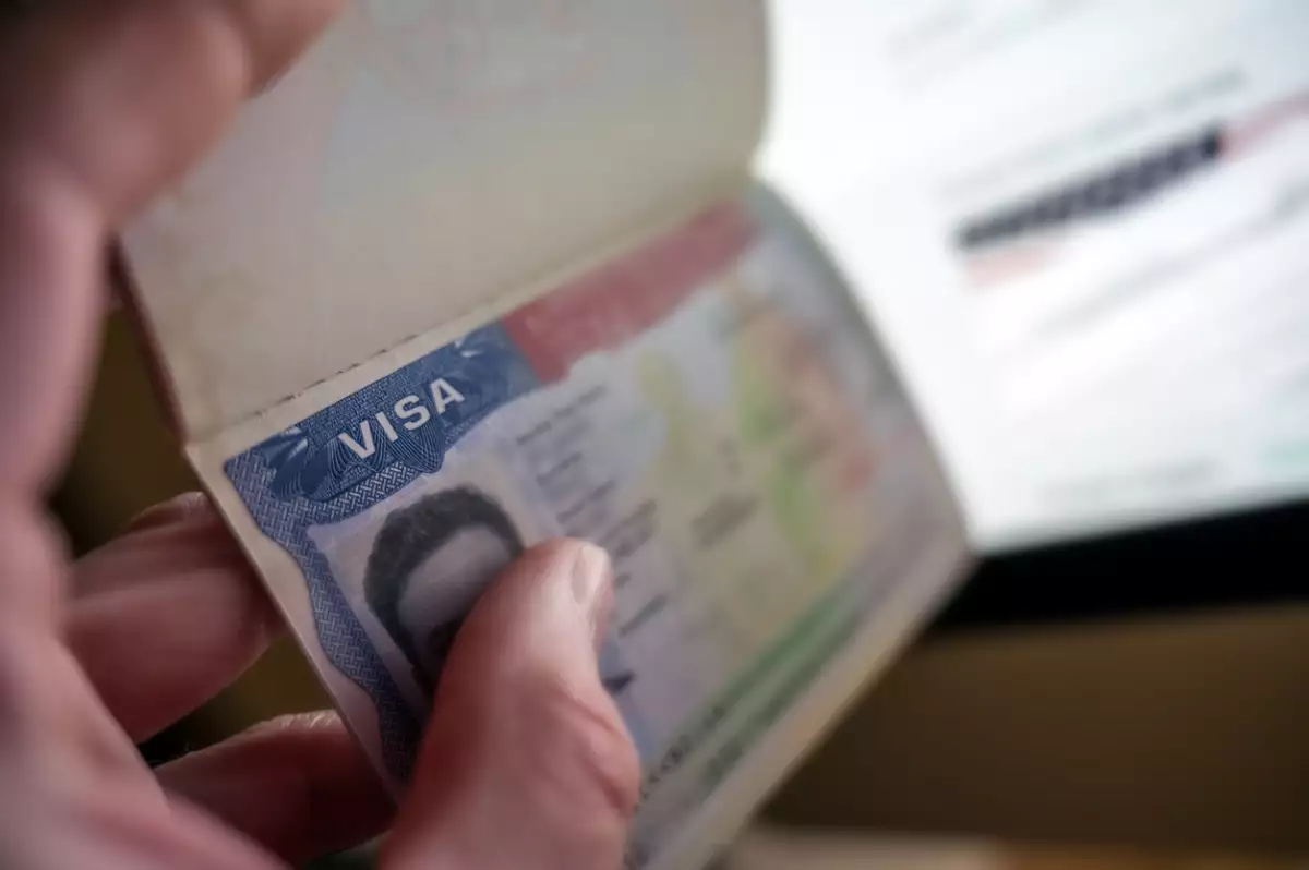 Unknown causian person holding passport with visa