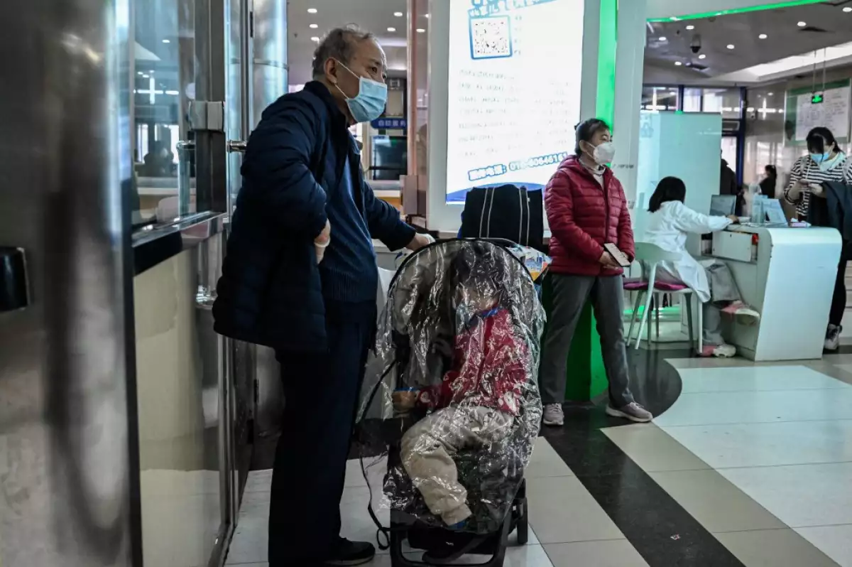Los niños y sus padres esperan en un área ambulatoria en un hospital infantil en Beijing el 23 de noviembre de 2023.