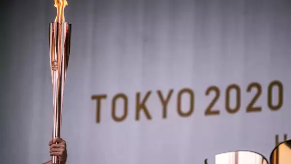 Un portador de la antorcha sostiene una antorcha olímpica durante la ceremonia de encendido de la llama olímpica en Machida Shibahiro, en el primer día del relevo de la antorcha en la ciudad de Machida, en el oeste de Tokio, el 9 de julio de 2021 (Foto de Philip FONG / AFP).