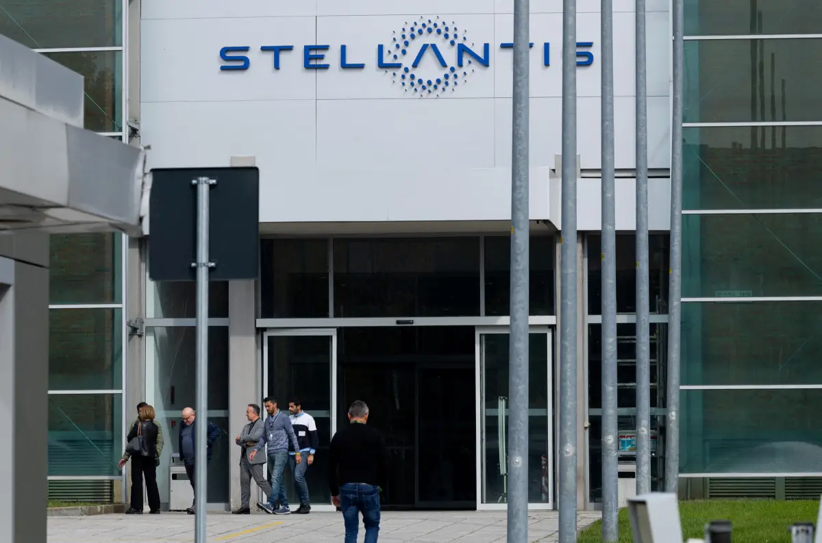 La gente camina junto a la puerta N.13 de la fábrica del fabricante de automóviles franco-italiano Stellantis de Mirafiori, en Turín, Italia, el 15 de octubre de 2024.