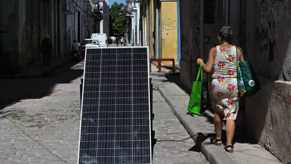 Una mujer pasa junto a un panel solar durante un corte de energía a nivel nacional en La Habana el 6 de julio de 2026.