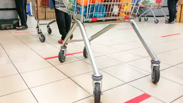 Social distancing being practiced at supermarket payment counter, with 1 meter gap between people in queue.